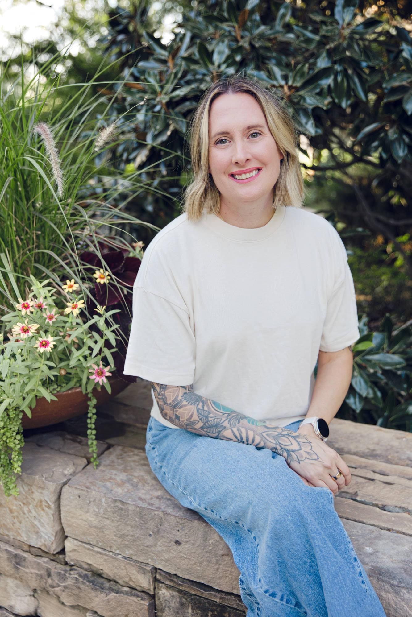 Ashley Layden is sitting down at the Myriad Botanical Gardens in Oklahoma City and smiling for a photo.