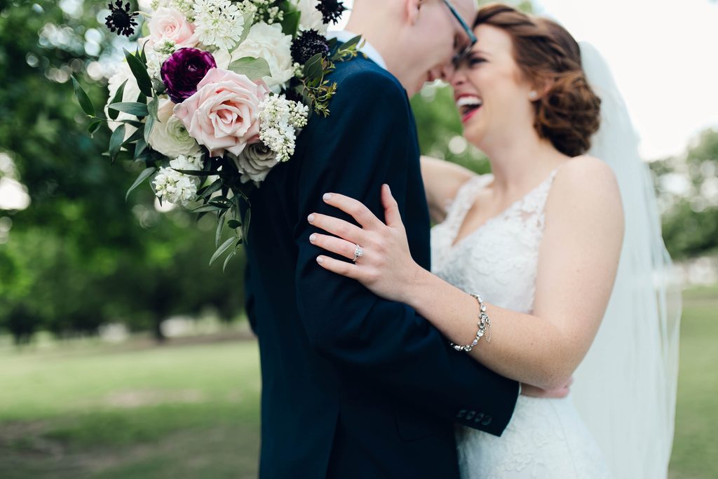 Bride & groom are standing forehead to forehead and are super relaxed, bride is smiling. they look calm, happy, and beautiful together.