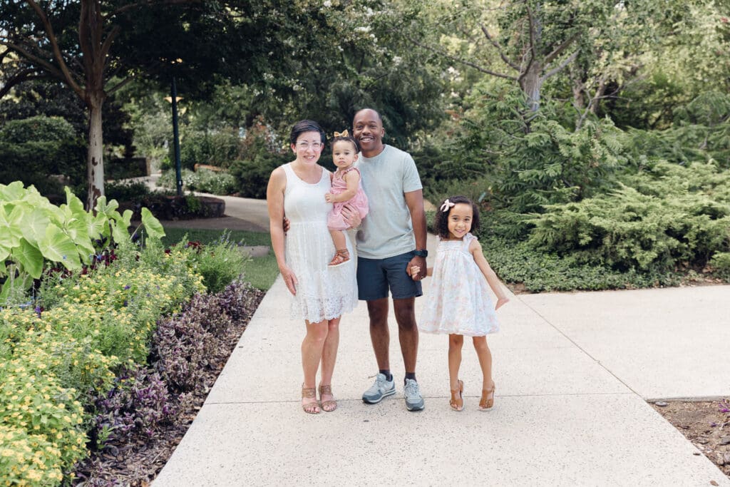 Family of 4 standing in Myriad Botanical Gardens for a family photo together in Oklahoma City.