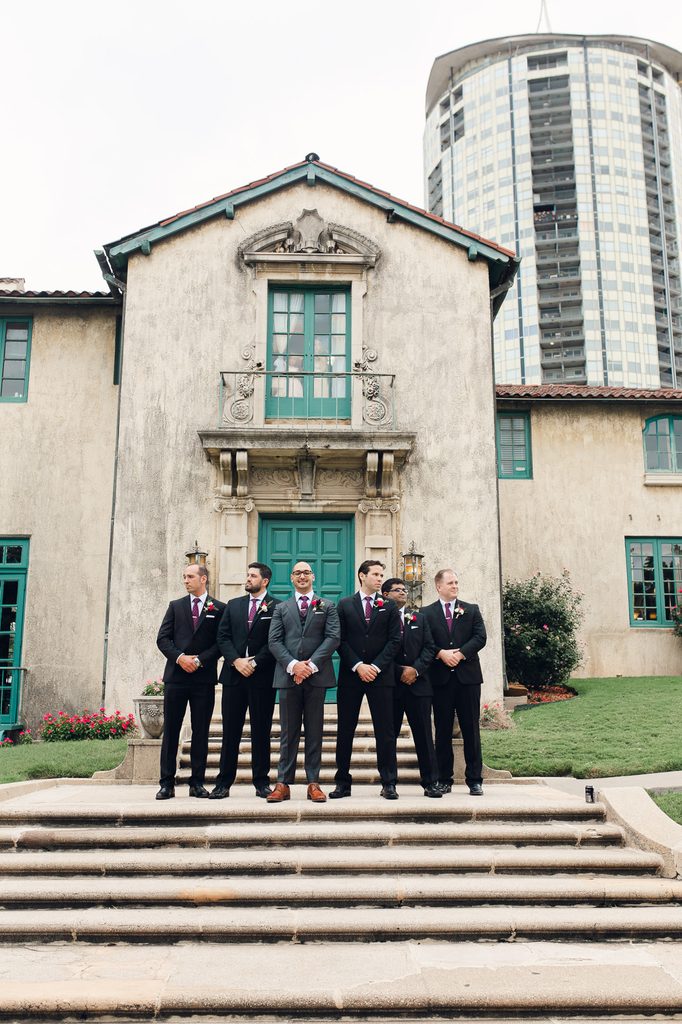 Keivan and his groomsmen standing on the front steps beneath Dresser Mansion’s blue-green doors and balcony. 