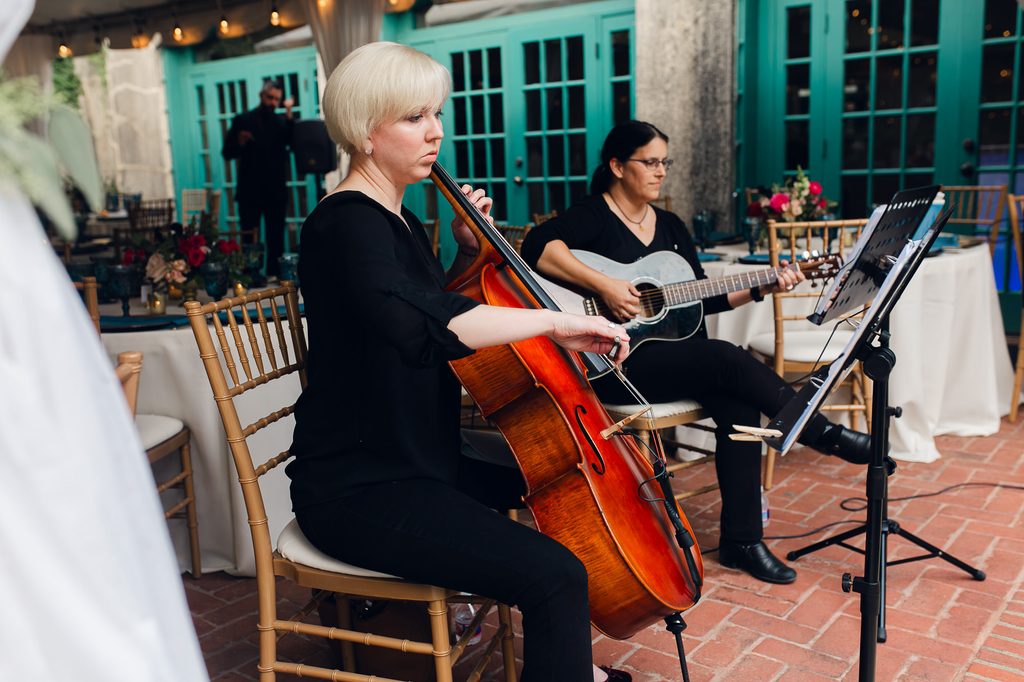 Cellist and acoustic guitarist performing beside the wedding reception tables at Dresser Mansion. 