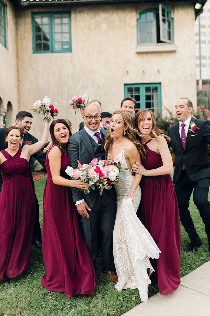 Megan, Keivan, and their wedding party cheering and raising bouquets outside the mansion. 