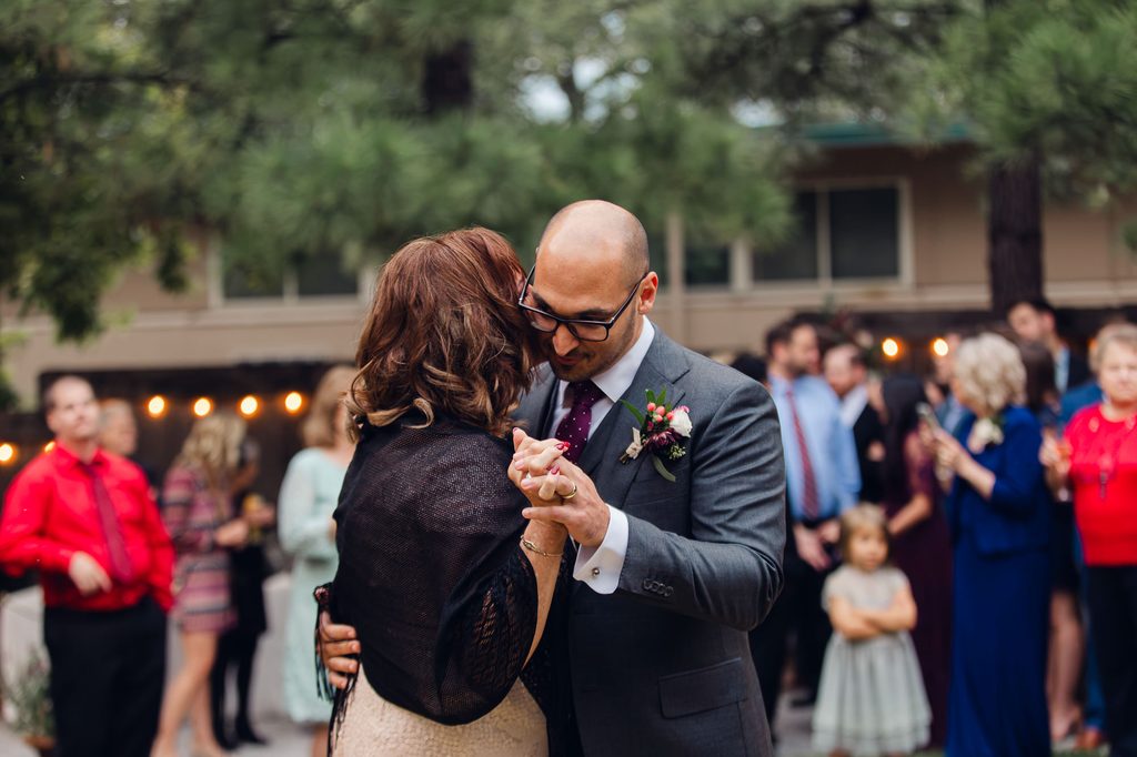 Keivan holding his mother close during their mother-son dance as wedding guests watch. 